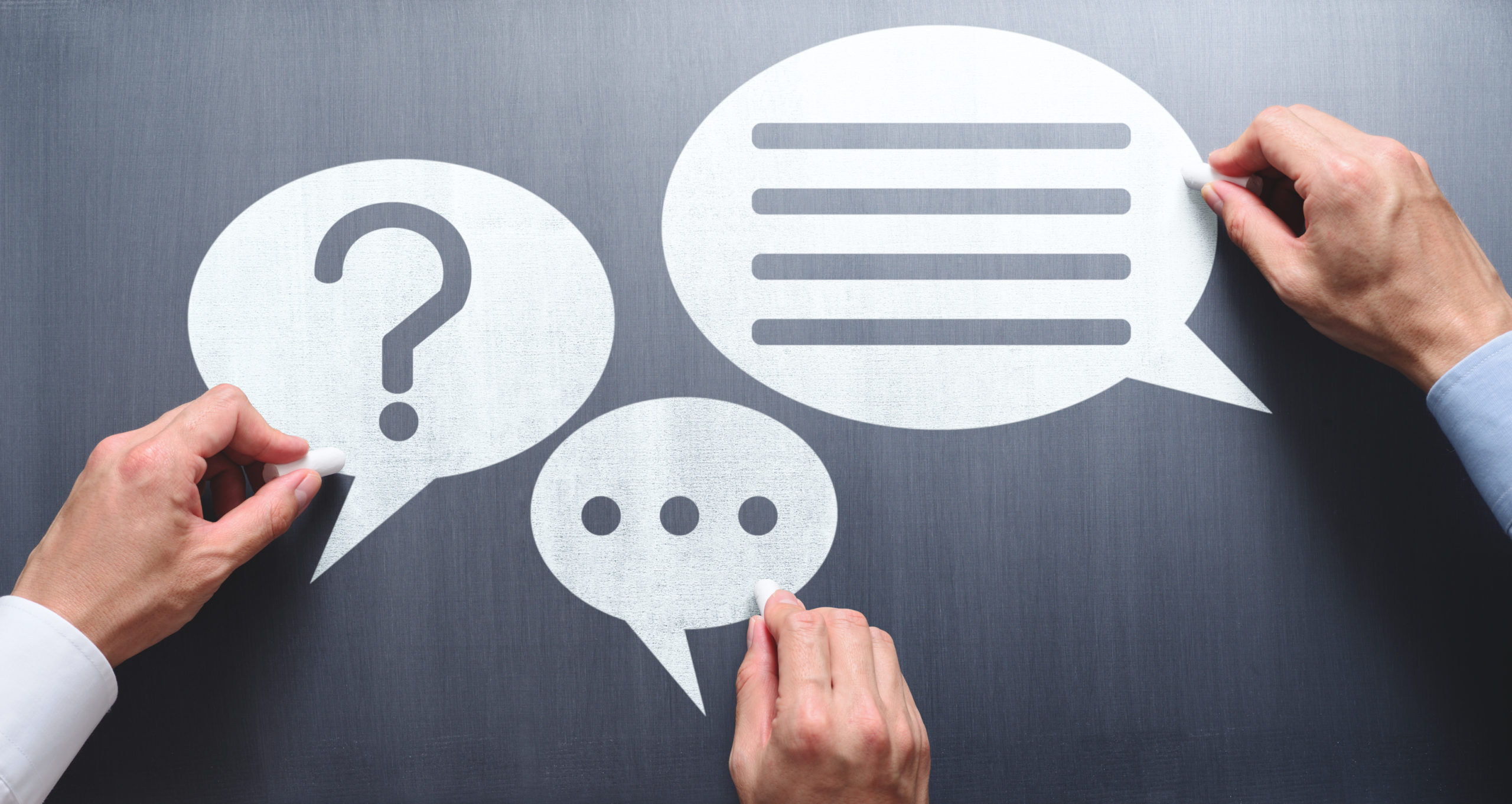 Business communication breakdown concept. Lack of communication skills. Businessmen drawing speech balloons on chalkboard. Business communication breakdown concept. Lack of communication skills. Businessmen drawing speech balloons on chalkboard.